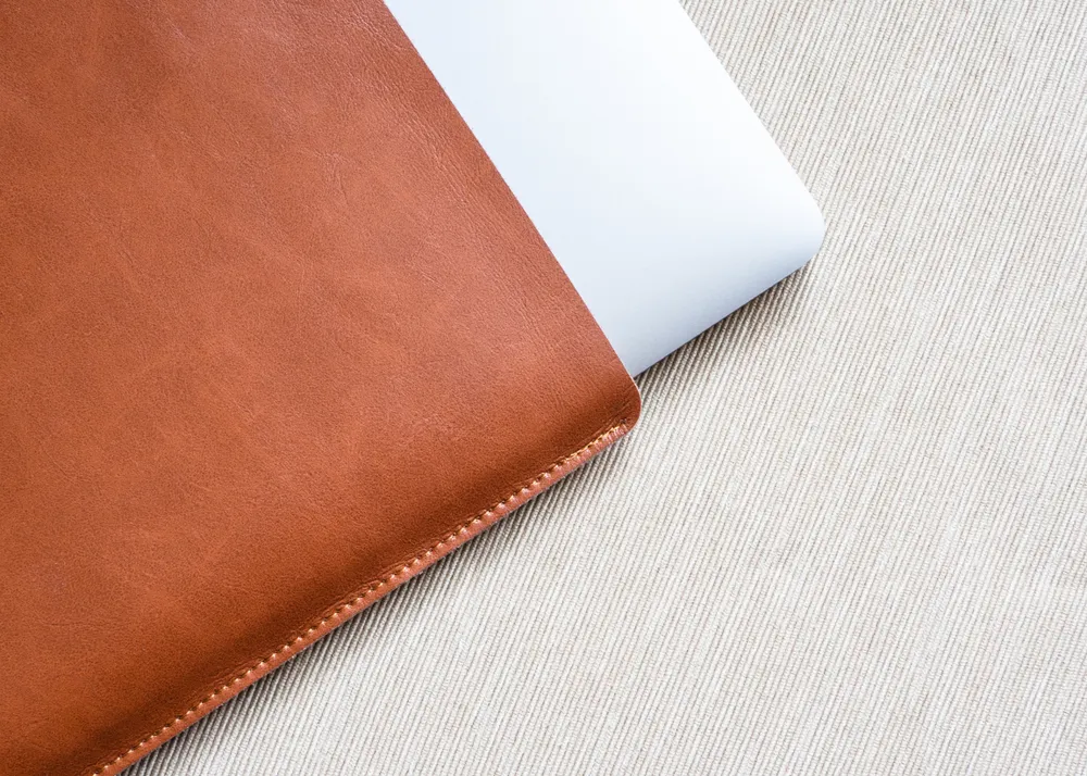 Laptop in a leather sleeve.
